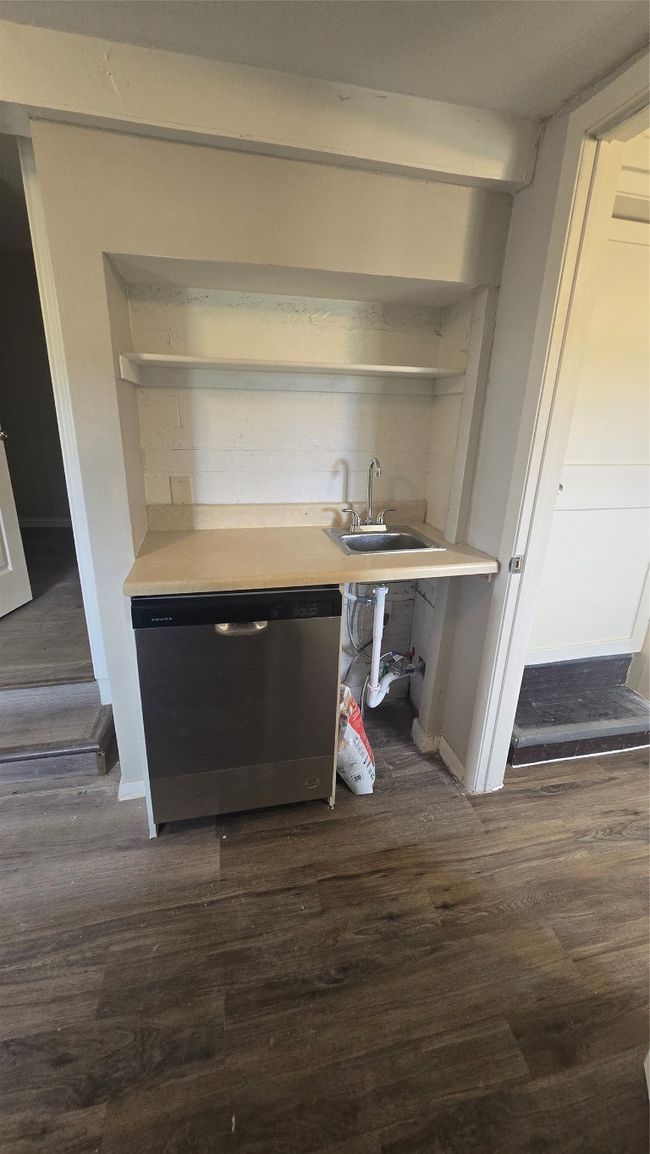 Bar with dark wood finished floors, dishwasher, a sink, baseboards, and indoor wet bar | Image 22