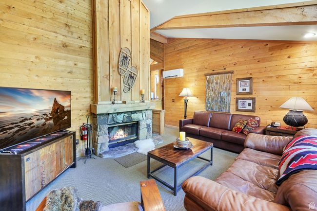 Living room featuring wood-burning fireplace and wall-mounted air conditioning and heat | Image 14