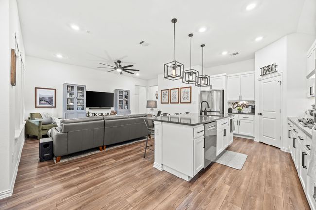 Kitchen with stainless steel appliances, open floor plan, a ceiling fan, a breakfast bar area, and recessed lighting | Image 4
