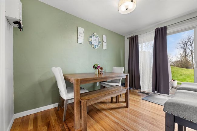 The dining area is light and bright with a sliding glass door leading to a patio. | Image 6