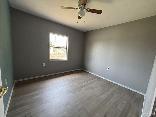 Spare room with wood finished floors, baseboards, and ceiling fan | Image 7