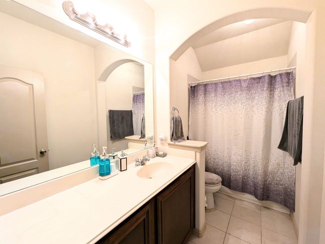 Full bath featuring vanity, tile patterned flooring, and a shower with shower curtain | Image 10