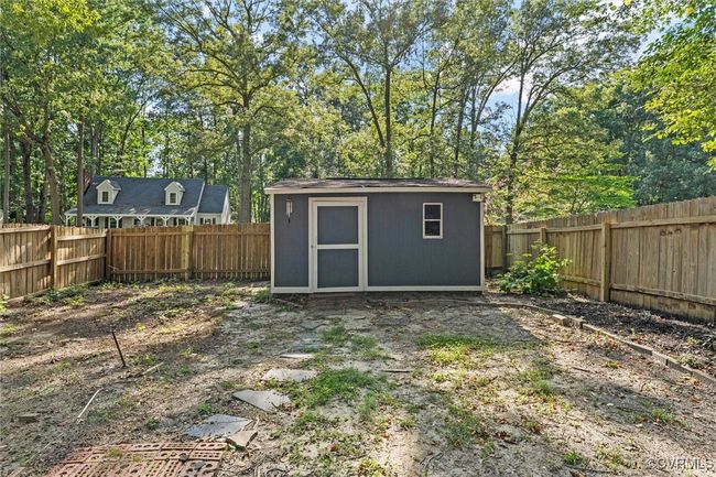 View of shed with a fenced backyard and view of wooded area | Image 39