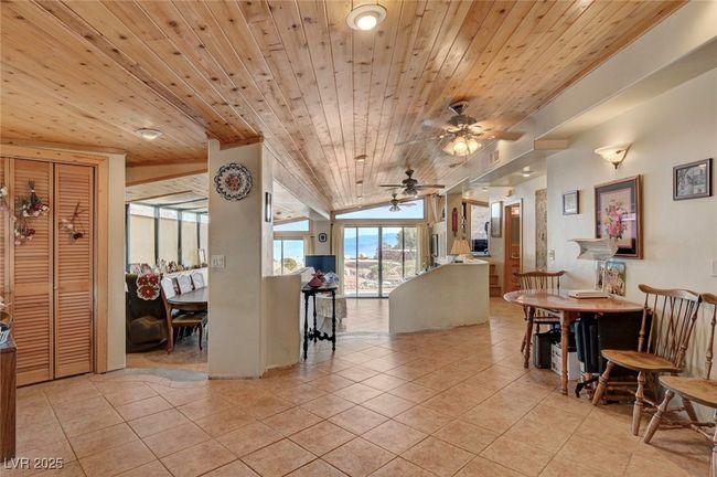 Dining room with light tile patterned floors, ceiling fan, wood ceiling, and lofted ceiling | Image 23