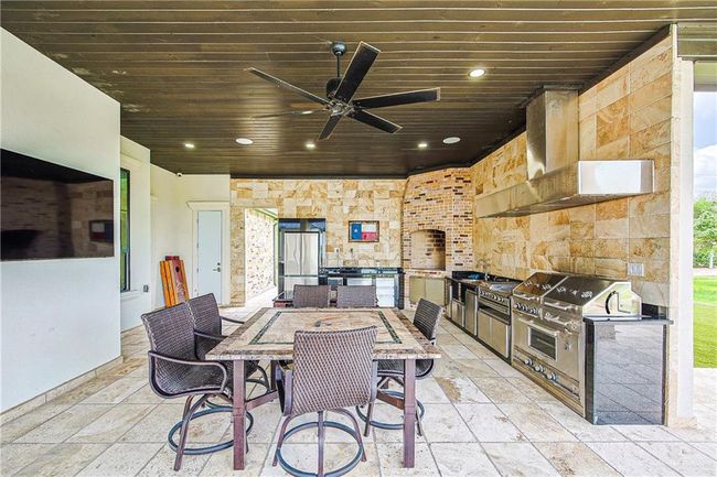 View of patio / terrace with area for grilling, outdoor dining area, and a ceiling fan, outdoor pantry, stainless steel appliances | Image 33