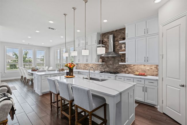 Kitchen featuring a sink, wall chimney exhaust hood, light countertops, decorative backsplash, and recessed lighting | Image 14