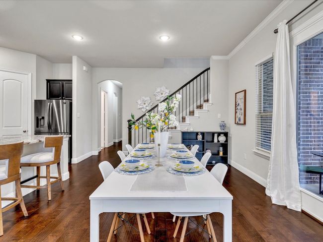 Dining space featuring arched walkways, stairway, dark wood-style flooring, recessed lighting, and crown molding | Image 9