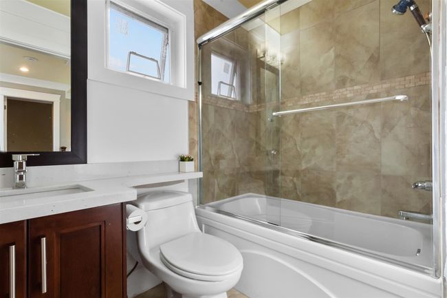 Bathroom featuring combined bath / shower with glass door, toilet, and vanity | Image 24