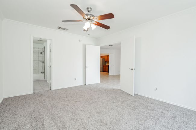 Unfurnished bedroom with crown molding, light carpet, and visible vents | Image 19