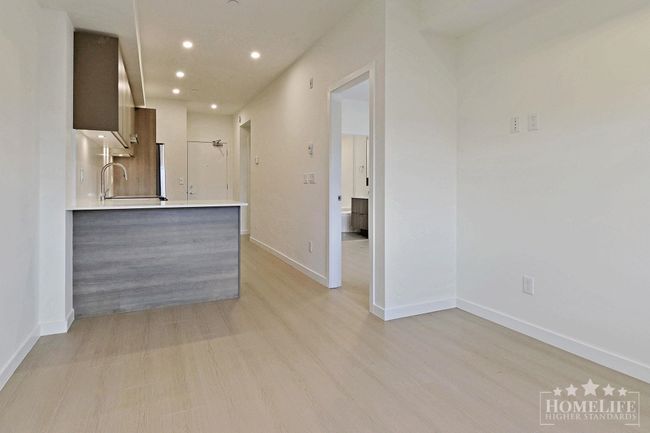 Interior space with light wood-style flooring, baseboards, recessed lighting, and a sink | Image 4