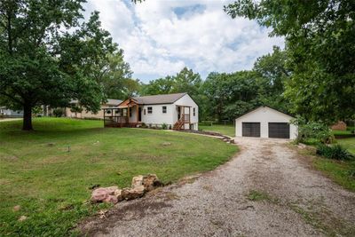 View of front of property with a garage, a front lawn, and an outbuilding | Image 1