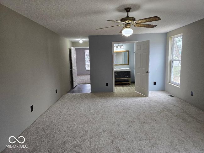 unfurnished room featuring a textured ceiling, a ceiling fan, visible vents, and light carpet | Image 21