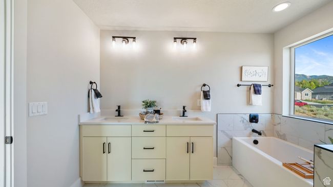 Bathroom with marble look tile flooring, a garden tub, and double vanity | Image 21
