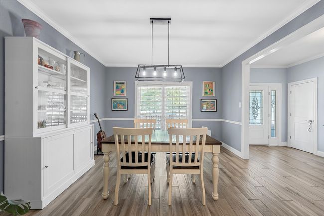 Dining room featuring ornamental molding, baseboards, and wood finished floors | Image 10