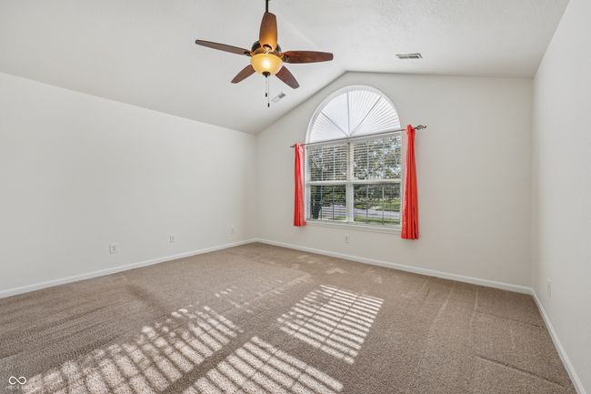 carpeted empty room featuring vaulted ceiling and ceiling fan | Image 27