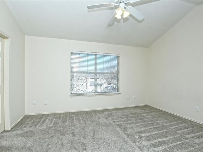 Empty room featuring carpet floors, ceiling fan, and vaulted ceiling | Image 13