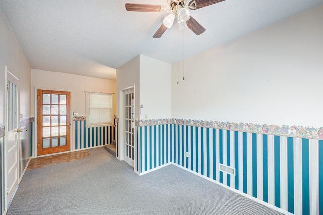 Empty room with carpet floors, a textured ceiling, and a ceiling fan | Image 18