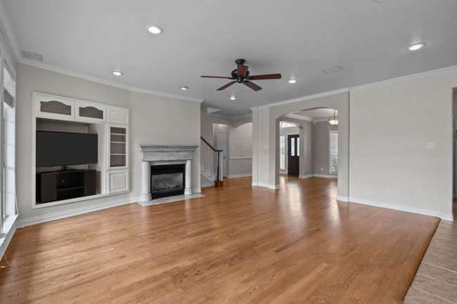 Oversized family room with traditional fire place and a wall of windows overlooking backyard | Image 9