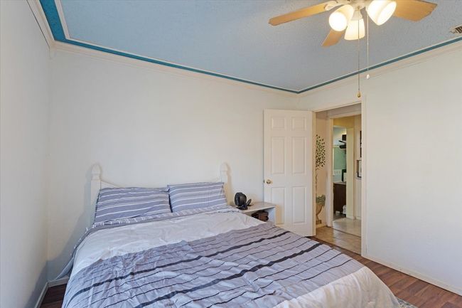 Bedroom featuring ornamental molding, hardwood / wood-style floors, a textured ceiling, and ceiling fan | Image 19