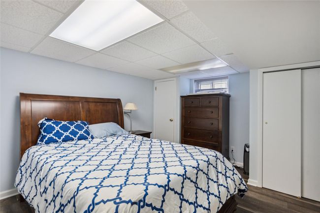 Bedroom with dark wood-type flooring, a drop ceiling, and a closet | Image 21