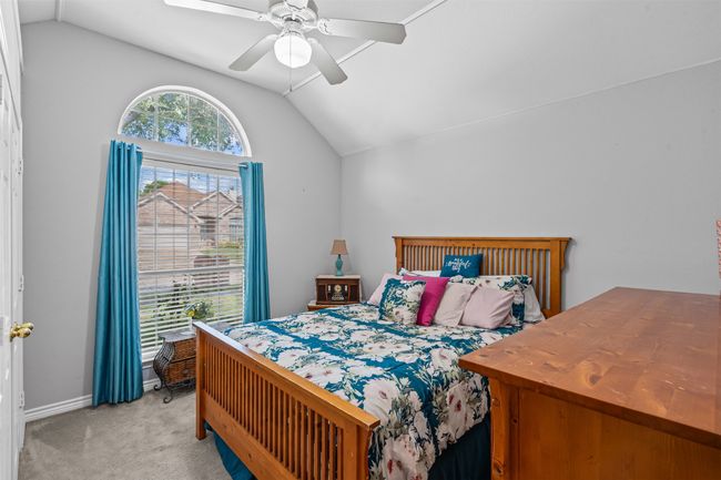 Bedroom featuring vaulted ceiling, light carpet, a ceiling fan, and baseboards | Image 16