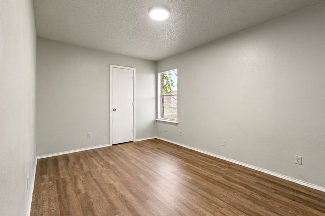Unfurnished bedroom featuring wood finished floors, baseboards, and a textured ceiling | Image 16