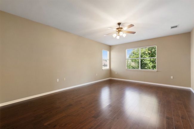 Spare room with ceiling fan, baseboards, and dark wood-style floors | Image 24
