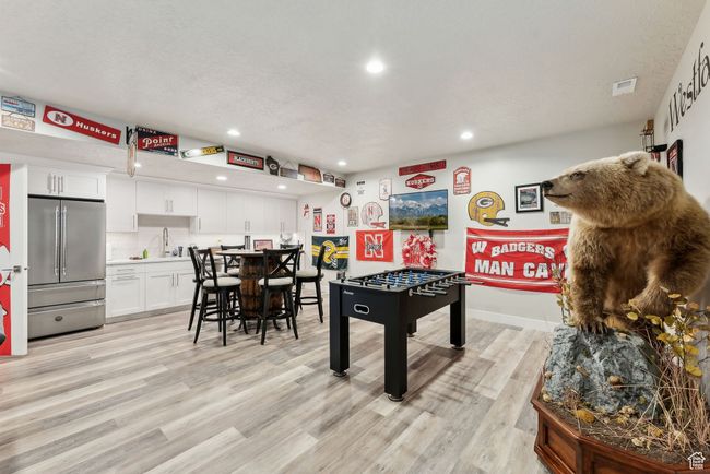 Rec room featuring light wood finished floors, recessed lighting, a sink, and visible vents | Image 34