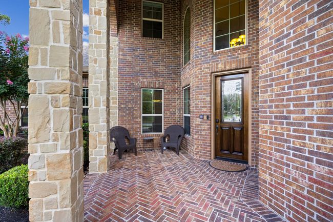 The entire exterior is a mix of brick & stone with the front porch featuring brick flooring on the way to the entry. | Image 5