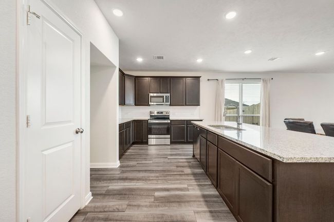 Open-concept kitchen flows seamlessly into living and dining, ideal for hosting and entertaining | Image 4