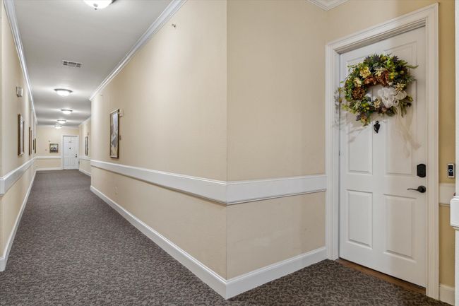 Hallway with dark carpet, ornamental molding, and baseboards | Image 27
