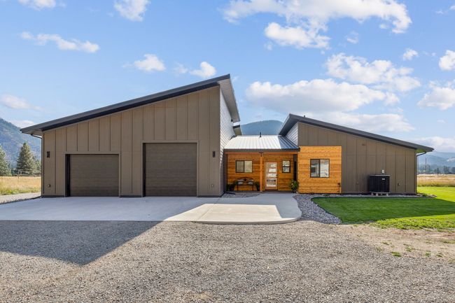 View of front of home with cooling unit, a garage, and a mountain view | Image 9