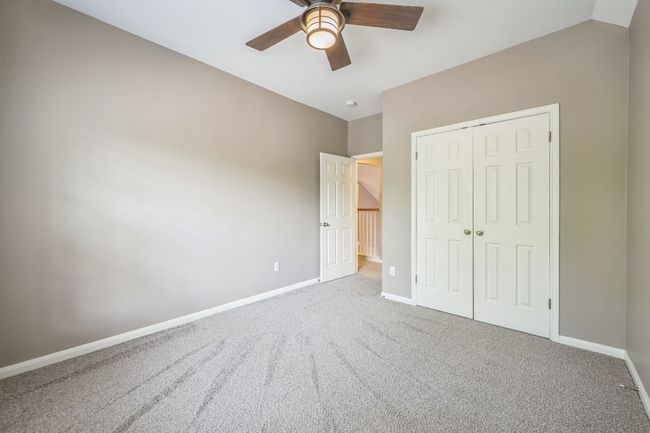 Unfurnished bedroom with carpet, a closet, baseboards, and ceiling fan | Image 22