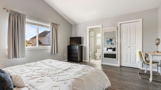 Bedroom featuring vaulted ceiling, a closet, baseboards, ensuite bath, and dark wood-type flooring | Image 17