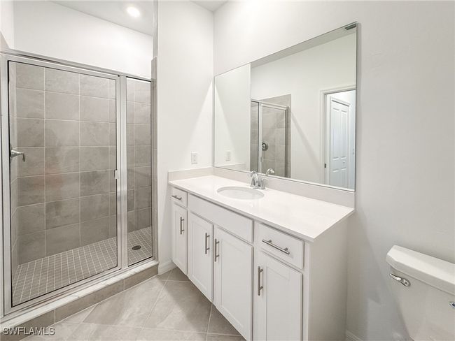 Bathroom featuring a stall shower, toilet, vanity, and tile patterned floors | Image 27