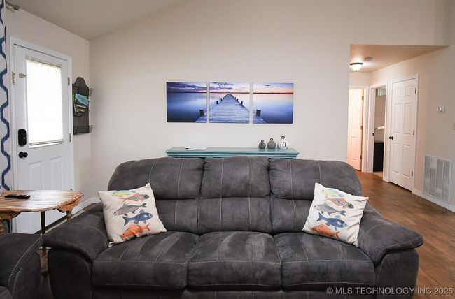 Living area featuring wood finished floors, baseboards, and lofted ceiling | Image 9