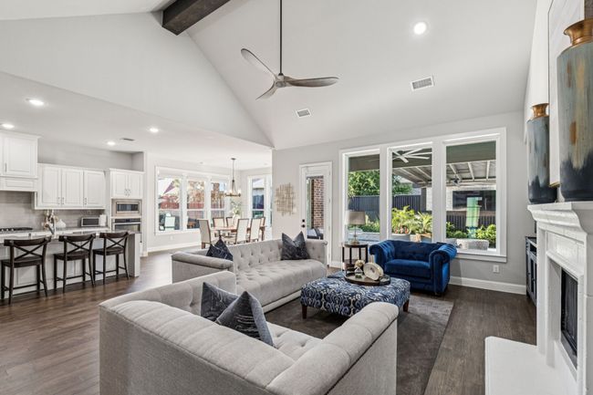 Living room featuring ceiling fan, beam ceiling, recessed lighting, high vaulted ceiling, and a fireplace with raised hearth | Image 9