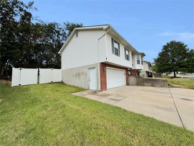 View of property exterior featuring a yard and a garage | Image 2