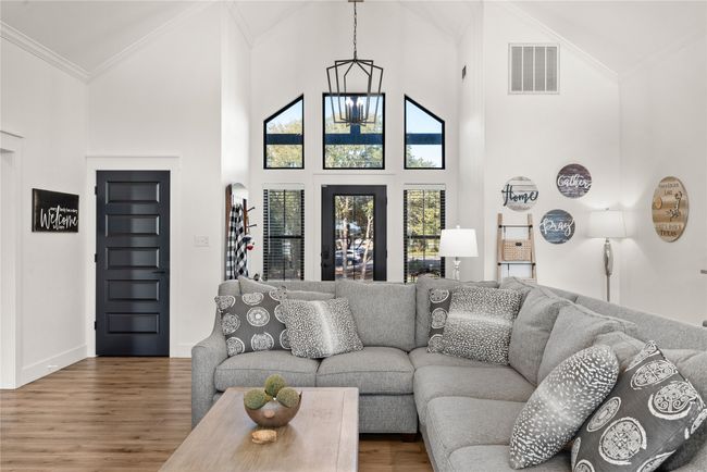 Living area with wood finished floors, ornamental molding, and high vaulted ceiling | Image 22