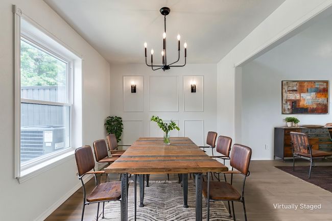 Dining room with a chandelier, healthy amount of natural light, and wood finished floors | Image 9