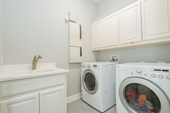 Laundry room with baseboards, cabinet space, washer and clothes dryer, and a sink | Image 14