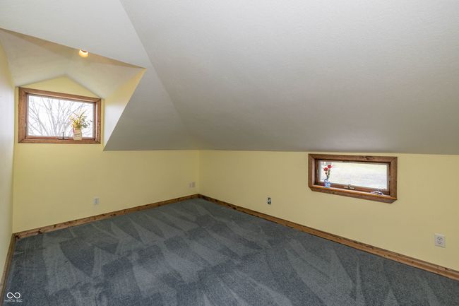 additional living space with vaulted ceiling, dark carpet, baseboards, and a wealth of natural light | Image 13