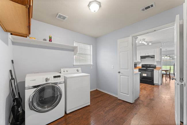Oversized laundry room featuring washing machine and clothes dryer and dark wood-type flooring | Image 9
