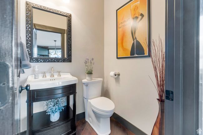 Bathroom with toilet, wood finished floors, a sink, and baseboards | Image 33