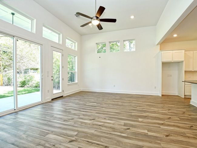 Unfurnished living room with recessed lighting, ceiling fan, light wood-style flooring, and a high ceiling | Image 6