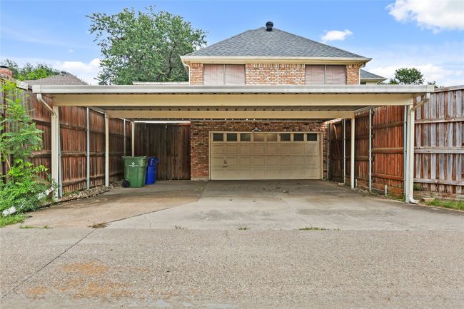 Garage with a carport and concrete driveway | Image 34