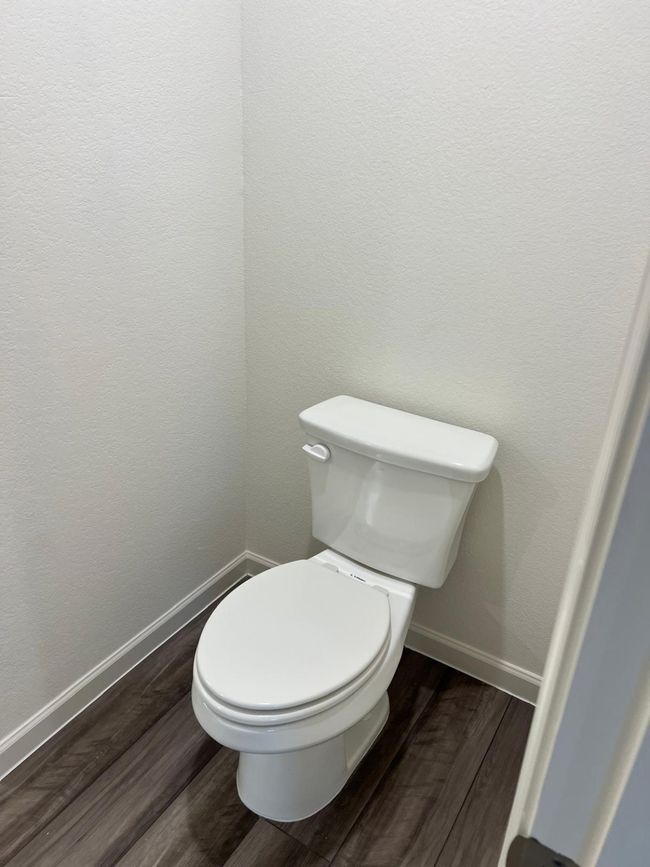 Bathroom featuring wood finished floors, baseboards, and toilet | Image 14