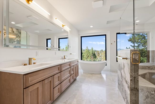 Spa-like Primary Bathroom with large picture windows, skylights, tub, large shower, double vanity and heated tile floor | Image 30