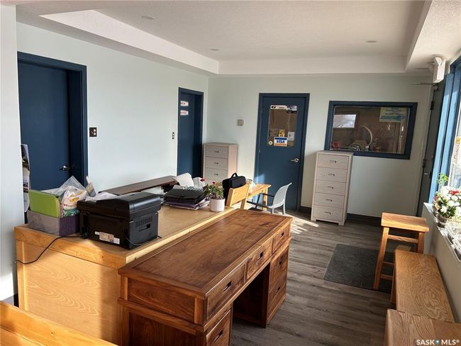 Home office featuring dark wood-type flooring and a tray ceiling | Image 15