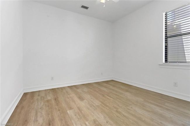 Spare room featuring light wood-type flooring, ceiling fan, baseboards, and healthy amount of natural light | Image 11
